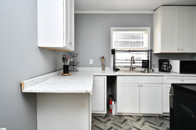 kitchen featuring light stone countertops, crown molding, white cabinetry, and sink