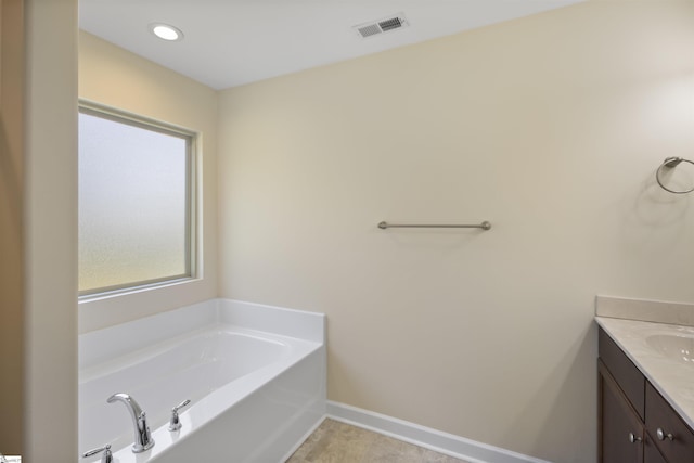 bathroom featuring a washtub and vanity