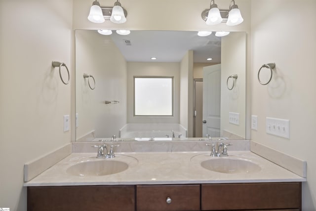 bathroom with a bathing tub, vanity, and a chandelier