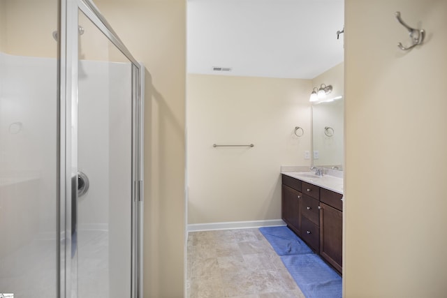 bathroom featuring vanity and a shower with door