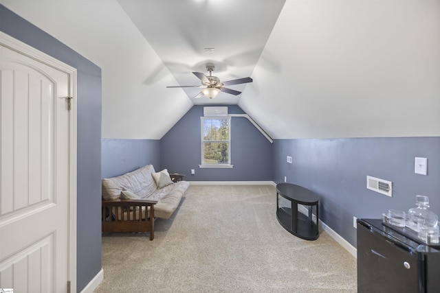 sitting room with ceiling fan, light carpet, and vaulted ceiling