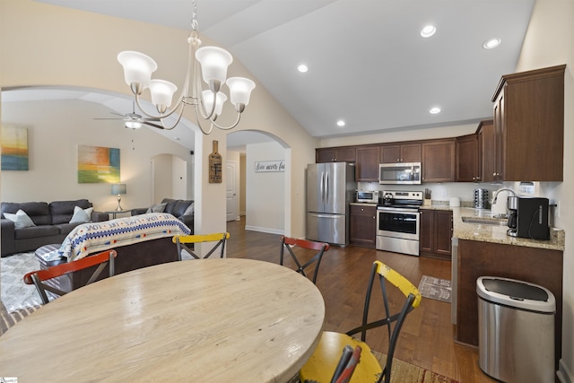 dining room with dark hardwood / wood-style flooring, sink, high vaulted ceiling, and ceiling fan with notable chandelier