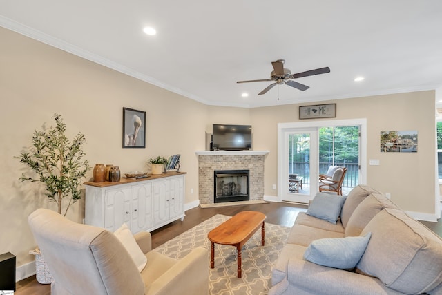 living room with a fireplace, hardwood / wood-style flooring, ceiling fan, and ornamental molding