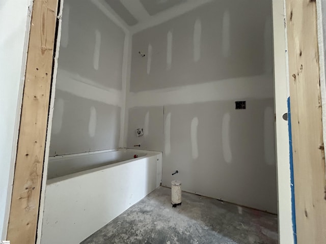 bathroom with a tub and concrete flooring