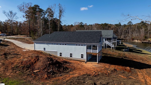 view of side of property featuring a sunroom and a water view