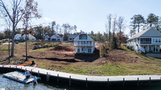 exterior space featuring a water view, a dock, and a balcony