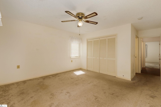 unfurnished bedroom with ceiling fan, a closet, and carpet floors