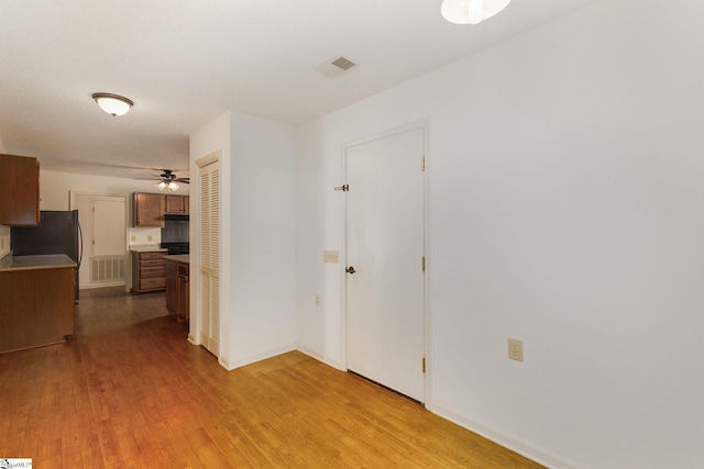 hallway with light hardwood / wood-style floors and a textured ceiling