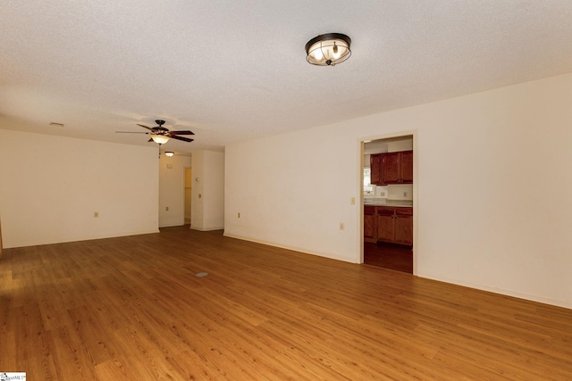 spare room featuring ceiling fan, wood-type flooring, and a textured ceiling