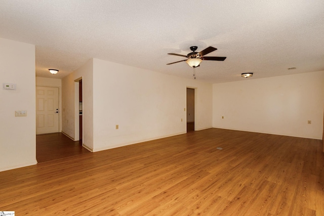 unfurnished room with ceiling fan, wood-type flooring, and a textured ceiling