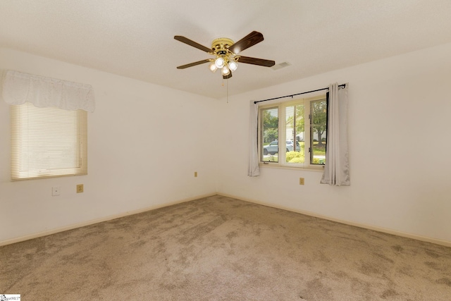 carpeted spare room featuring ceiling fan