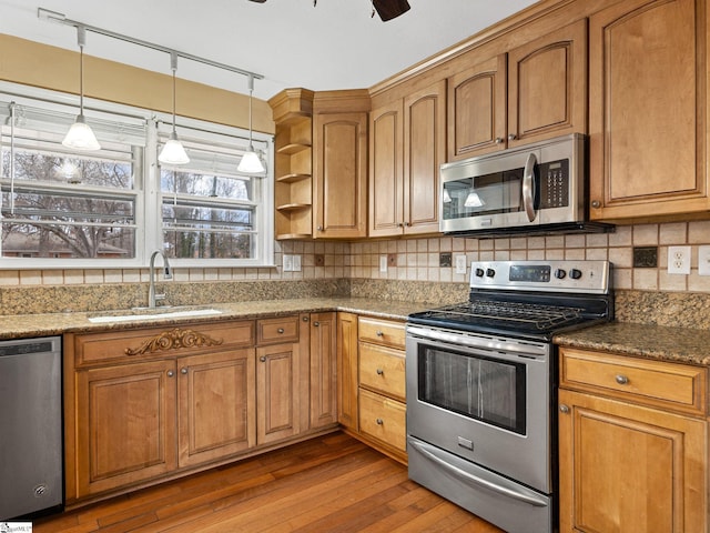 kitchen with tasteful backsplash, dark stone countertops, sink, and stainless steel appliances