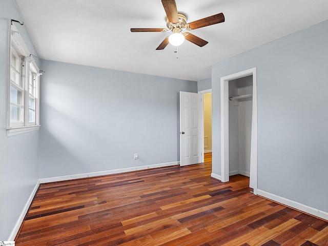 unfurnished bedroom with ceiling fan, a closet, and dark wood-type flooring