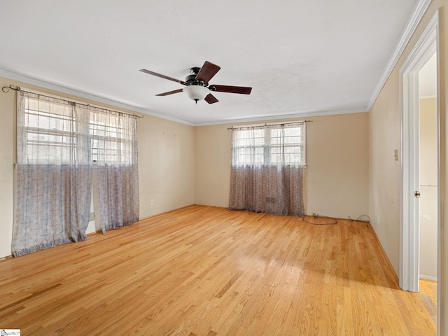 empty room featuring ceiling fan, light wood-type flooring, and ornamental molding