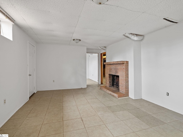 unfurnished living room featuring light tile patterned floors and a brick fireplace