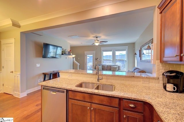 kitchen with dishwasher, sink, ceiling fan, decorative backsplash, and light stone counters