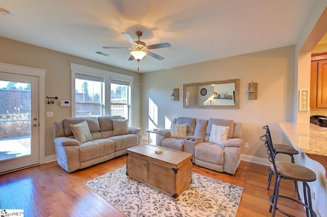 living room with ceiling fan and light hardwood / wood-style flooring