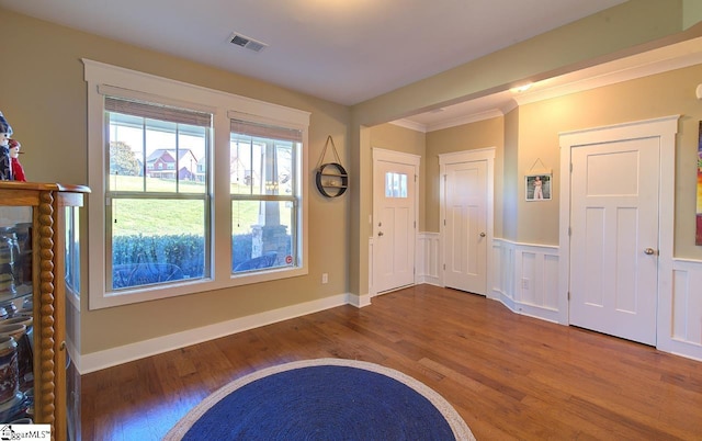 entrance foyer featuring crown molding and hardwood / wood-style flooring