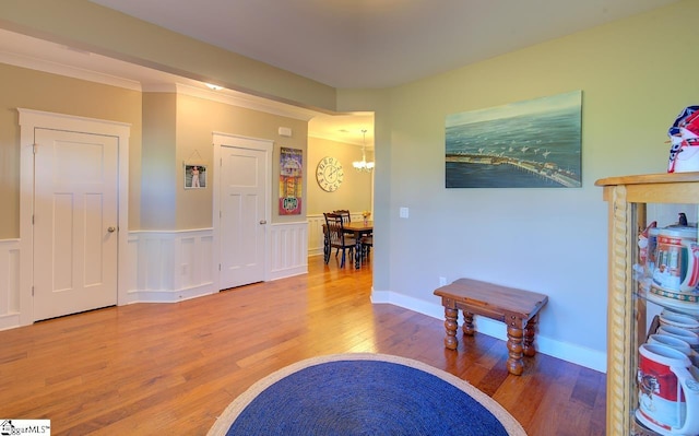 interior space with ornamental molding, a notable chandelier, and hardwood / wood-style flooring