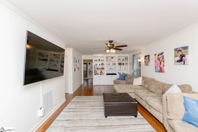 living room featuring ceiling fan, wood-type flooring, built in features, and ornamental molding