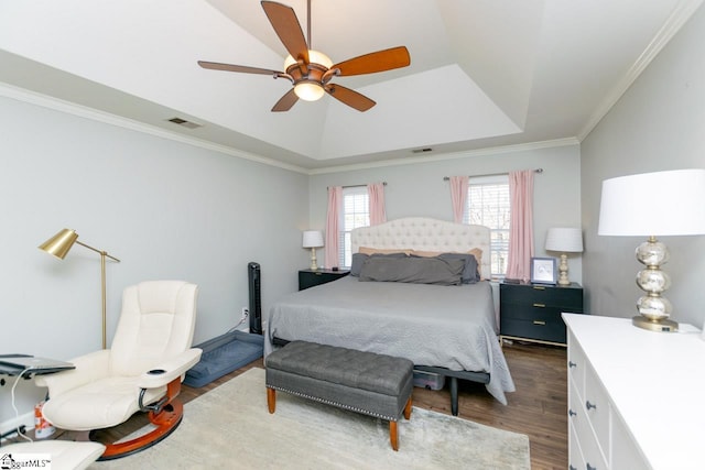 bedroom with a tray ceiling, ceiling fan, ornamental molding, and dark hardwood / wood-style floors