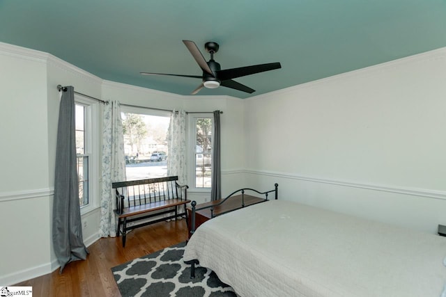 bedroom with hardwood / wood-style flooring, ceiling fan, and crown molding