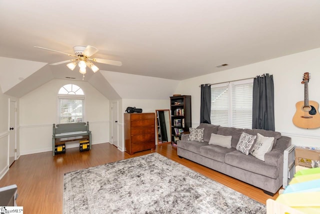 living room with hardwood / wood-style flooring, vaulted ceiling, and ceiling fan