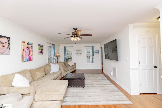 living room with ceiling fan, light wood-type flooring, and ornamental molding