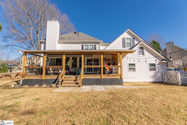 back of property featuring a lawn and a wooden deck