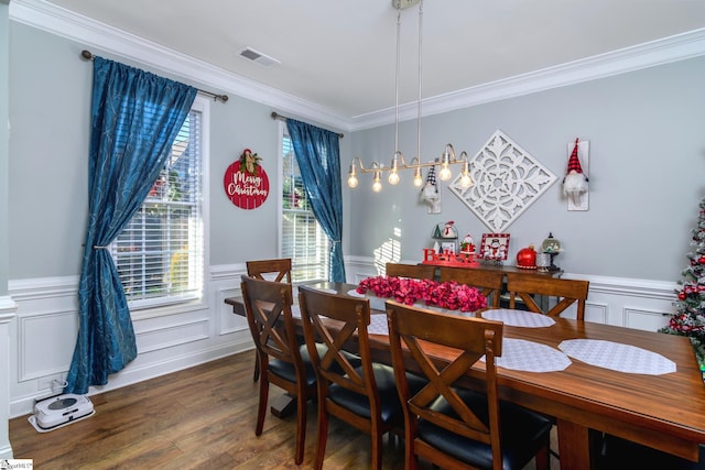 dining room featuring dark hardwood / wood-style floors, ornamental molding, and an inviting chandelier