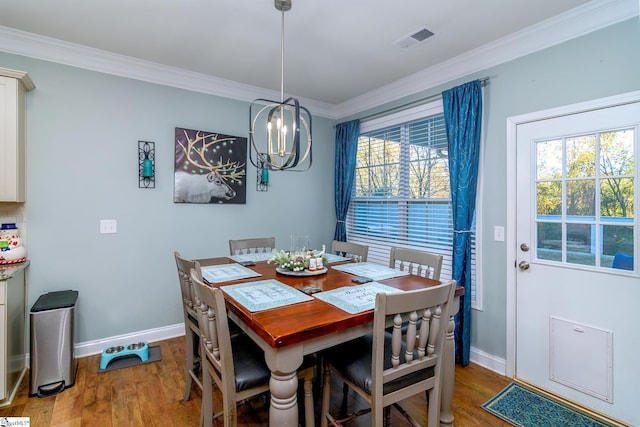 dining room featuring hardwood / wood-style floors, plenty of natural light, ornamental molding, and a chandelier