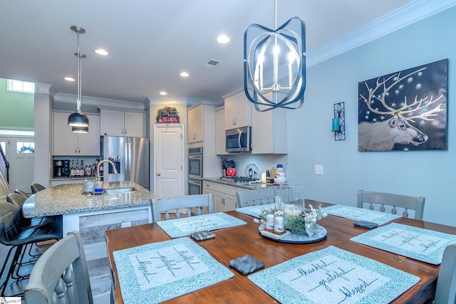 dining space with crown molding, sink, hardwood / wood-style flooring, and an inviting chandelier