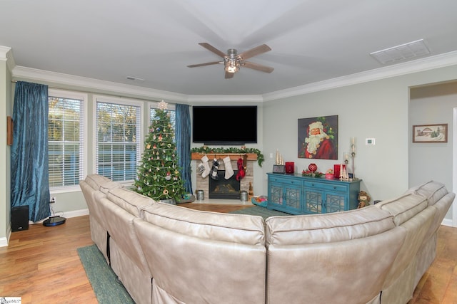 living room with crown molding, light hardwood / wood-style flooring, and ceiling fan