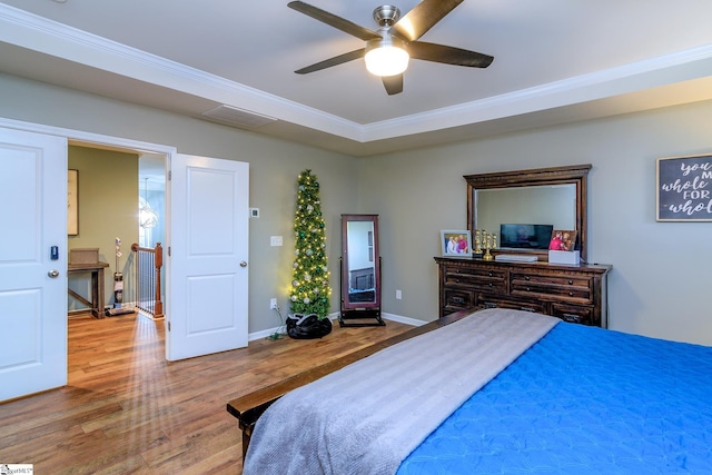 bedroom with hardwood / wood-style flooring, ceiling fan, and crown molding