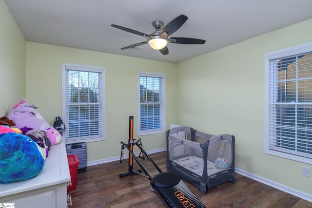 exercise area with ceiling fan and dark hardwood / wood-style flooring