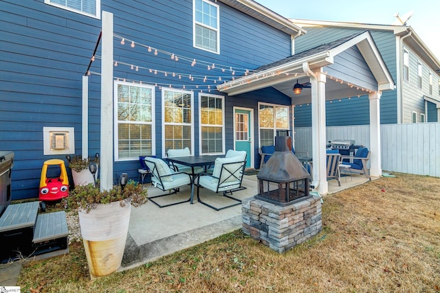 rear view of property featuring a fire pit, ceiling fan, and a patio area