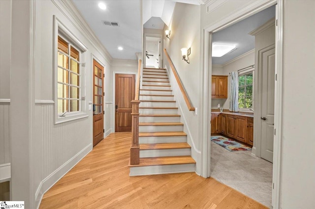 stairway featuring hardwood / wood-style floors and crown molding