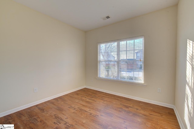 unfurnished room with hardwood / wood-style floors