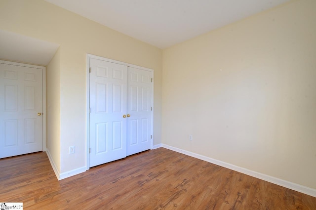 unfurnished bedroom featuring a closet and wood-type flooring