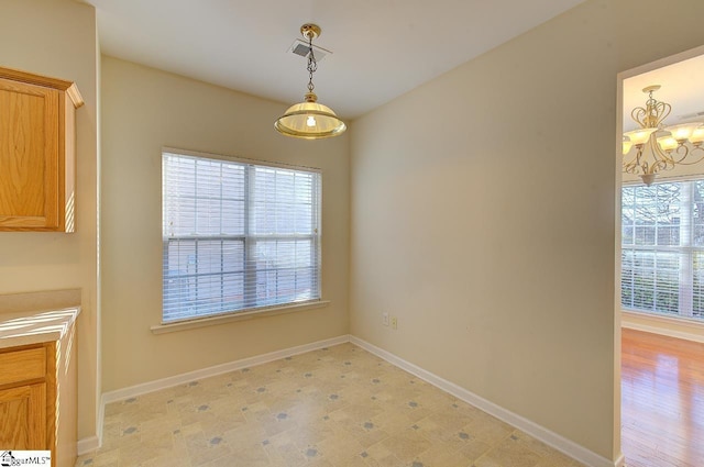 unfurnished dining area featuring a chandelier