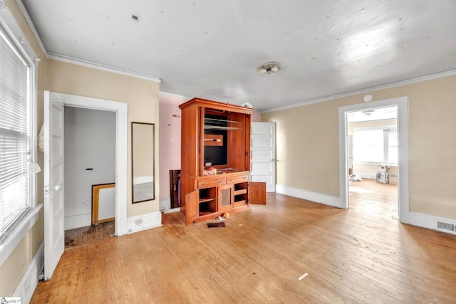 living room with ornamental molding and light hardwood / wood-style flooring