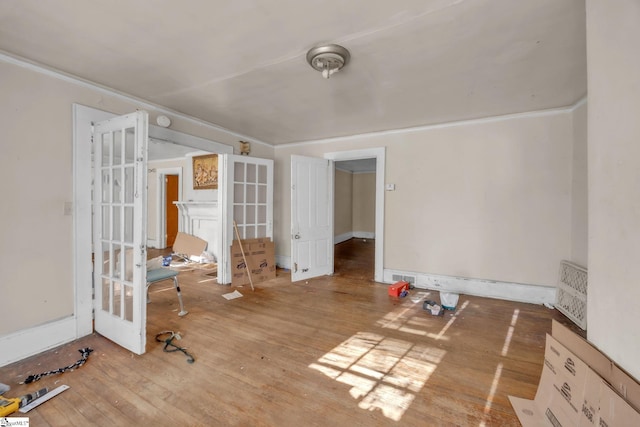 unfurnished room with wood-type flooring, crown molding, and french doors