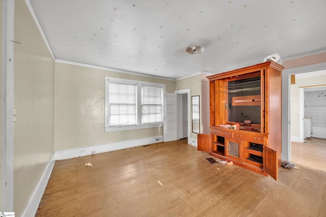 unfurnished living room featuring light hardwood / wood-style floors and crown molding