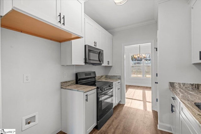 kitchen featuring light stone countertops, white cabinets, black range, and hardwood / wood-style flooring