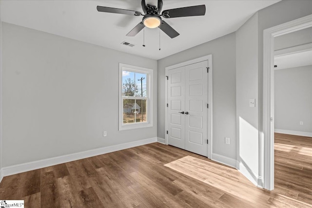 unfurnished bedroom featuring hardwood / wood-style floors and ceiling fan