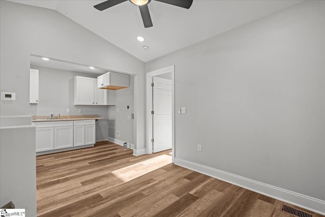 interior space with ceiling fan, light hardwood / wood-style flooring, sink, and vaulted ceiling