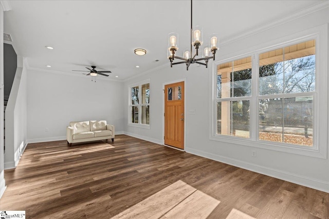 unfurnished room featuring crown molding, wood-type flooring, and ceiling fan with notable chandelier