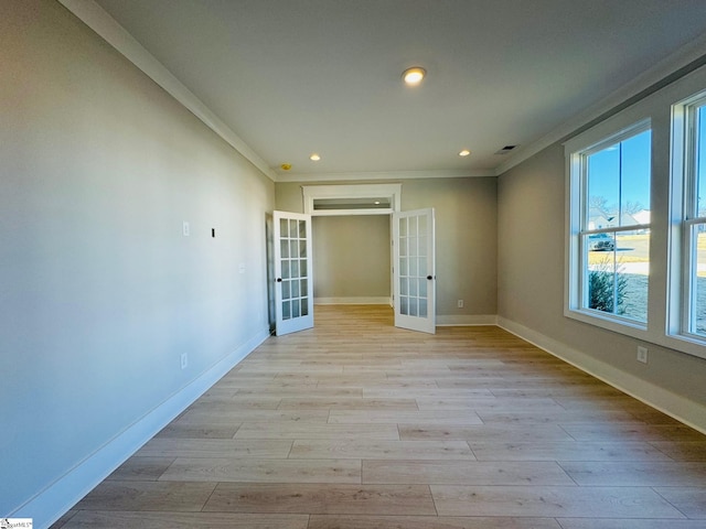 spare room featuring light hardwood / wood-style floors, ornamental molding, and french doors