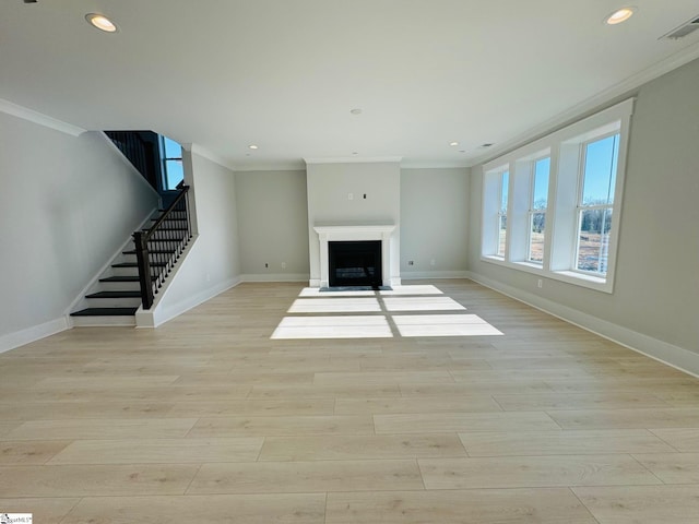 unfurnished living room with crown molding and light hardwood / wood-style flooring