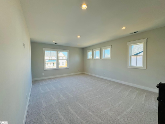 empty room featuring light carpet and plenty of natural light